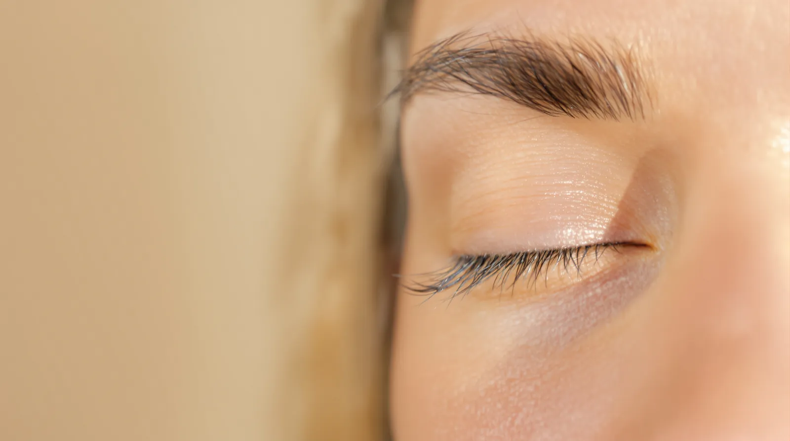 A close-up of a closed eye with long natural eyelashes